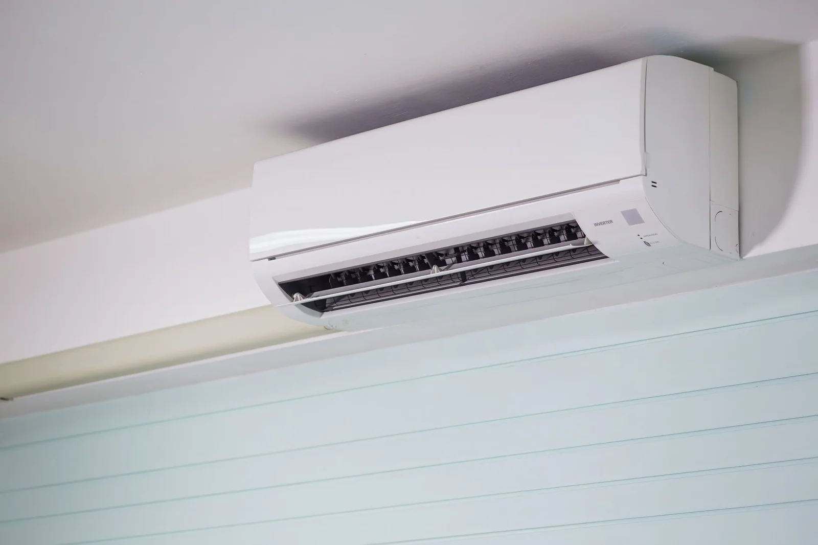 Pièce de vie avec unité murale de PAC air-air installée en hauteur